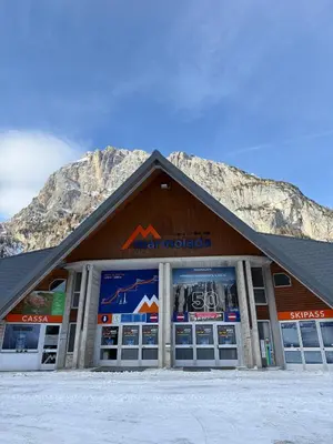 a large building with a mountain in the background at Malga Ciapela e Marmolada a due passi dalle piste in Malga Ciapela