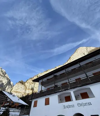 a white building with mountains in the background at Malga Ciapela e Marmolada a due passi dalle piste in Malga Ciapela
