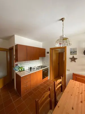 a kitchen with wooden cabinets and a wooden table at Malga Ciapela e Marmolada a due passi dalle piste in Malga Ciapela