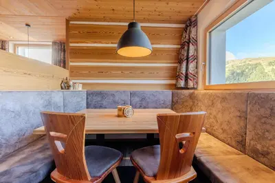 a dining room with a table and chairs and a window at Zischgalm in Obereggen