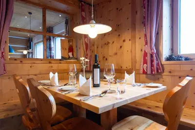 a dining room with a table with wine glasses at Zischgalm in Obereggen
