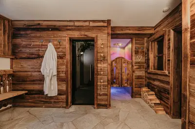 a bedroom with a bed and a desk and windows at Gutonhof in Selva di Val Gardena