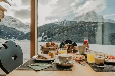 a group of chairs in a room with a painting on the wall at Gutonhof in Selva di Val Gardena