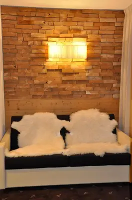 a bedroom with a brick wall and a bed with pillows at Terra - The Magic Place Relais & Châteaux in Sarntal