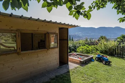 a wooden house with a hot tub and a motorcycle next to it at Baumgartnerhof in Lagundo