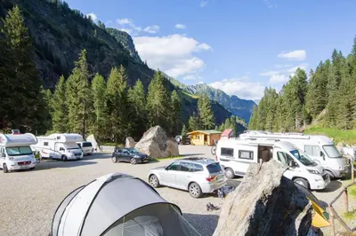 a group of vehicles parked in a parking lot at Camping Bergkristall in Moso