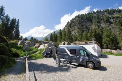 a van parked in a parking lot with a trailer at Camping Bergkristall in Moso