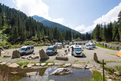 a group of vehicles parked in a parking lot at Camping Bergkristall in Moso
