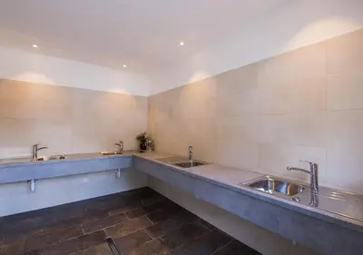a bathroom with three sinks and two faucets at Camping Bergkristall in Moso