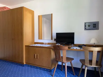 a room with a desk with a computer and two chairs at Hotel Friedemann in Rasùn di Sotto
