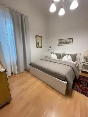 a bedroom with a bed and a large window at Appartamenti Duomos in Merano