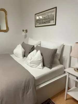 a bed with pillows on it in a room at Appartamenti Duomos in Merano