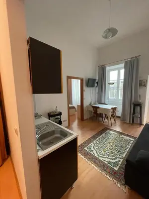 a living room with a kitchen and a living room with a table at Appartamenti Duomos in Merano