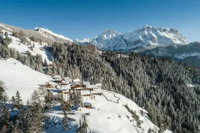 a ski lodge on a snowy mountain with snow covered mountains at Mountain Chalet Pia in La Valle