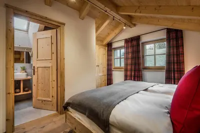 a bedroom with a bed in a room with wooden ceilings at Mountain Chalet Pia in La Valle