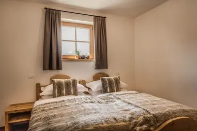 a bedroom with a bed and a window with curtains at Mountain Chalet Pia in La Valle