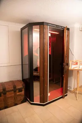 a glass elevator in a room with a table at Gasthof Innerwalten in San Leonardo in Passiria