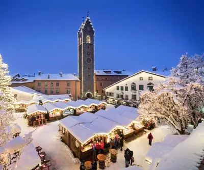 a christmas market in a town with a clock tower at Gasthof Innerwalten in San Leonardo in Passiria