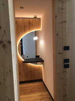 a hallway with a wooden wall with a mirror at Pra Ciarea Apartments in Ortisei