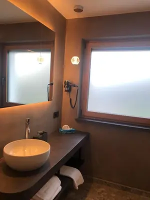 a bathroom with a sink and a large mirror at Pra Ciarea Apartments in Ortisei