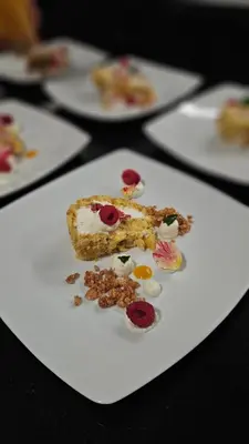 a white plate with a piece of cake on a table at Berghotel zum Zirm in Collalbo