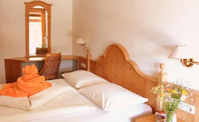 an orange towel on a bed in a room at Berghotel zum Zirm in Collalbo