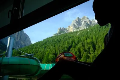 a person sitting in a helicopter looking out a window at a mountain at Vidor Resort in Pozza di Fassa