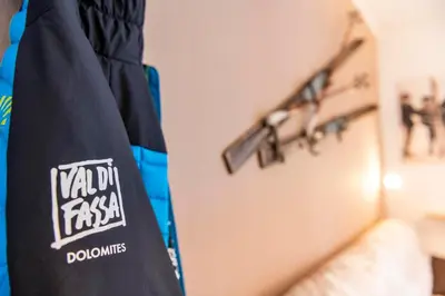 a black bag with a sticker on it next to a rail at Appartamenti Residence La Roggia in Pozza di Fassa