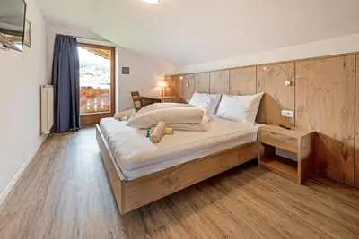 a bedroom with a large bed with a wooden headboard at Residence Condor in Maranza