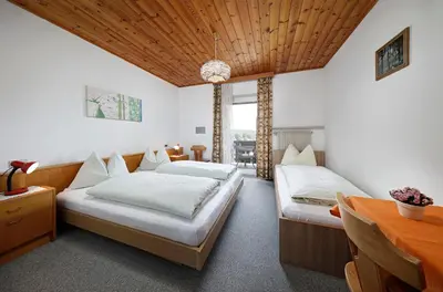 a bedroom with two beds and a wooden ceiling at Gasthof Mesnerwirt in Auna di Sopra