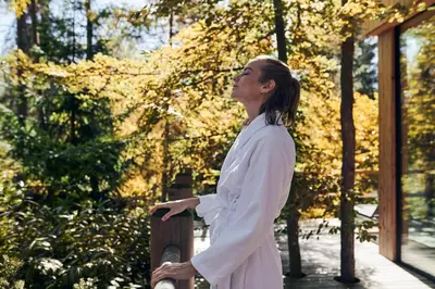 a woman standing on a fence in a park at B&B Obermair in Brunico