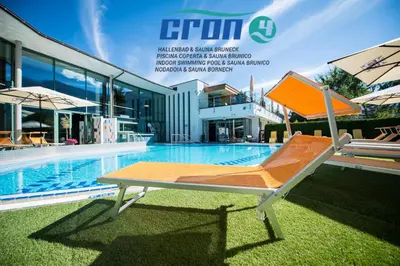 a lounge chair next to a swimming pool at B&B Obermair in Brunico