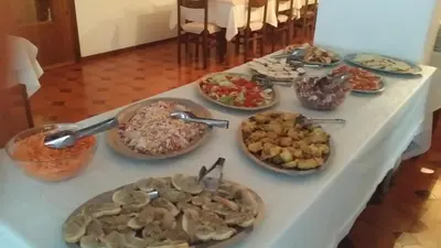 a table with many plates of food on it at Hotel Nevada in Campitello di Fassa