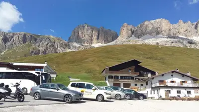 a group of cars parked in front of a mountain at Hotel Nevada in Campitello di Fassa