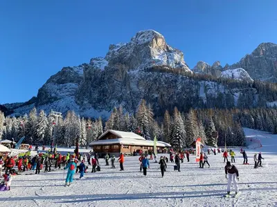 a group of people skiing in the snow in front of a mountain at Casa Vacanze Villa Elena in Alleghe