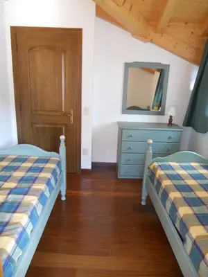 a bedroom with two beds and a dresser and a mirror at Casa Vacanze Villa Elena in Alleghe