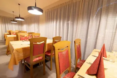 a large living room with purple chairs and a table at Hotel Primula in Campitello di Fassa