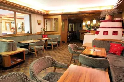a dining room with a long table and chairs at Hotel Primula in Campitello di Fassa