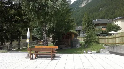 a restaurant with tables and chairs and a cake at Hotel Primula in Campitello di Fassa