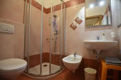 a bedroom with two beds and a large window at Cesa Rotic in Canazei