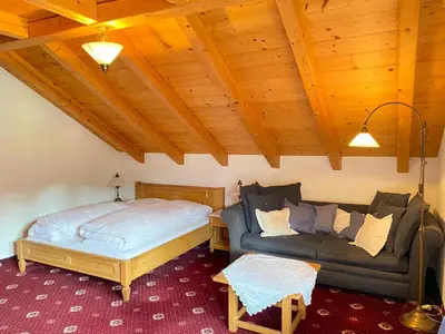 a living room with a bed and a couch at Im weißen Schlössl Friedemann in Rasùn di Sotto