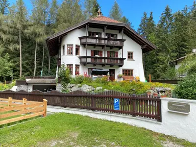 a large house with a fence in front of it at Im weißen Schlössl Friedemann in Rasùn di Sotto