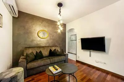 a living room with a couch and a flat screen tv at Appartements König in Merano