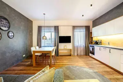 a kitchen and living room with a table and a dining room at Appartements König in Merano