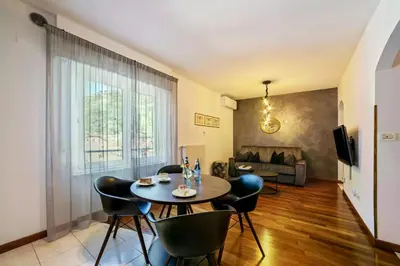 a living room with a table and chairs and a couch at Appartements König in Merano