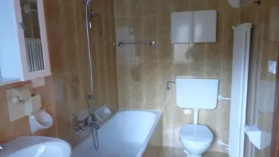 a bathroom with a tub and a toilet and a shower at Appartamento Lidia Astor in Alleghe