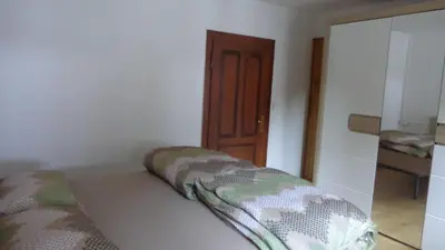 a room with a bed in a room with a door at Appartamento Lidia Astor in Alleghe