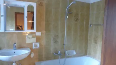 a bathroom with a tub and a sink and a shower at Appartamento Lidia Astor in Alleghe