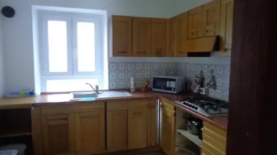 a kitchen with wooden cabinets and a sink and a window at Appartamento Lidia Astor in Alleghe