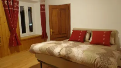 a bedroom with a bed with red pillows on it at Appartamento Lidia Astor in Alleghe
